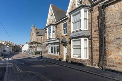 an old brick building with white windows on a street at Room 3 Hotel style Double bedroom in Marazion in Marazion