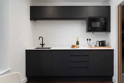a kitchen with black cabinets and a sink at Room 3 Hotel style Double bedroom in Marazion in Marazion