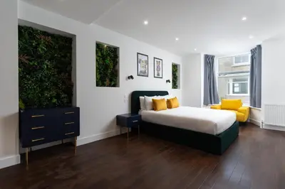 a bedroom with a bed and a dresser with yellow pillows at Room 1, Hotel style double bedroom in Marazion in Marazion