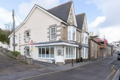 a white building on the corner of a street at Room 1, Hotel style double bedroom in Marazion in Marazion