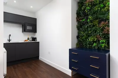 a kitchen with a plant wall and a blue dresser at Room 1, Hotel style double bedroom in Marazion in Marazion