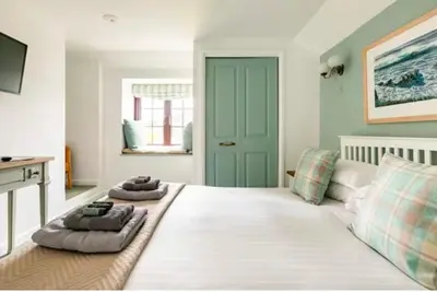a large white bed with two pillows on top of it at Kota Restaurant & Rooms in Porthleven