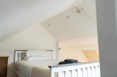 a bedroom with a bed in a white room at Kota Restaurant & Rooms in Porthleven