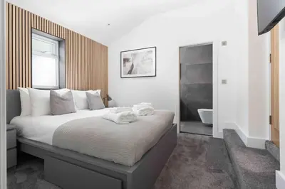 a bedroom with a large bed and a bathroom at Stunning new fully renovated flat in Marazion in Marazion