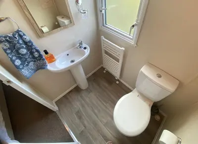 a small bathroom with a toilet and a sink at Gannets Rest - Spacious Static Caravan with Sea Views in Polperro