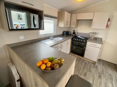 a kitchen with a bowl of fruit on a counter at Gannets Rest - Spacious Static Caravan with Sea Views in Polperro