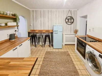 a kitchen with a refrigerator and a table with chairs at The Annex At Tenniside in Perranporth