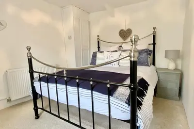 a bedroom with a bed with a wrought iron bed frame at Stable Cottage in Delabole