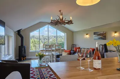 a living room with a table with wine glasses on it at Meadowside in Saint Mawes