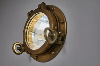 a bronze mirror on a white wall at Meadowside in Saint Mawes