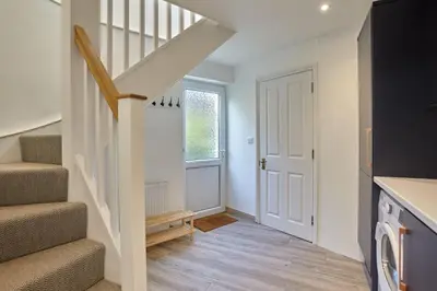 a staircase in a house with a white door at Meadowside in Saint Mawes