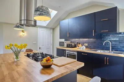 a kitchen with blue cabinets and a counter top at Meadowside in Saint Mawes