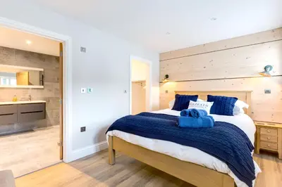 a bedroom with a large bed with blue towels on it at Breakers View in Wadebridge