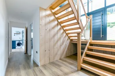 a wooden staircase in a house with a hallway at Breakers View in Wadebridge