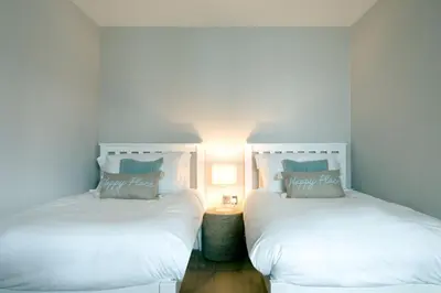 two beds sitting next to each other in a bedroom at Breakers View in Wadebridge