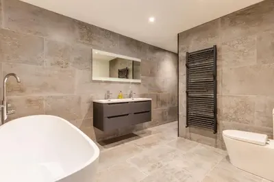 a bathroom with a tub and a sink and a toilet at Breakers View in Wadebridge
