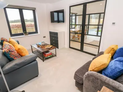 a living room with two couches and a table at Tredarn in Hayle