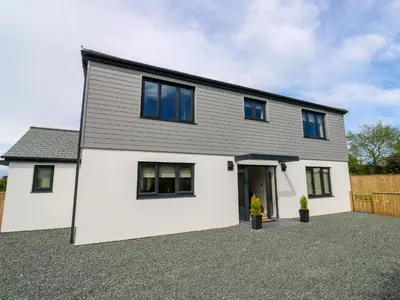 a white house with black windows on a driveway at Tredarn in Hayle