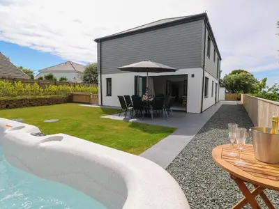 a backyard with a pool and a table with an umbrella at Tredarn in Hayle