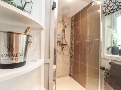 a bathroom with a shower with a glass door at Inny Brook Cottage in Camelford