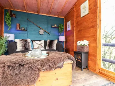 a living room with a table and a couch at Inny Brook Cottage in Camelford