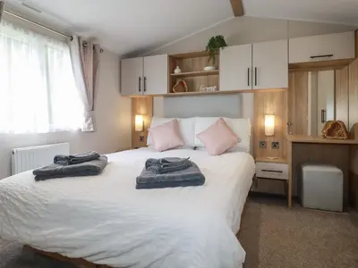 a bedroom with a large bed with two towels on it at Pams Place in Newquay