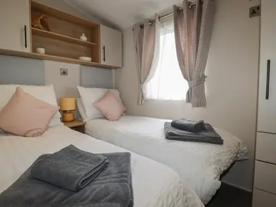 two beds in a small room with a window at Pams Place in Newquay