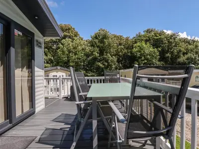 a deck with a table and chairs on a house at Pams Place in Newquay