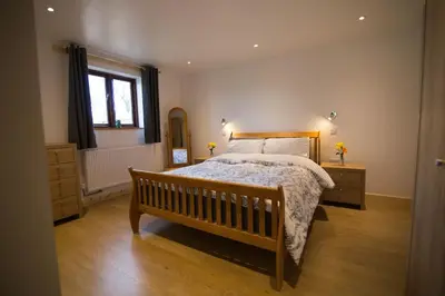 a bedroom with a large bed and a window at Hendra Retreat Owls Roost Cottage North Cornwall in Camelford