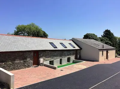 a building with solar panels on the side of it at Hendra Retreat Owls Roost Cottage North Cornwall in Camelford