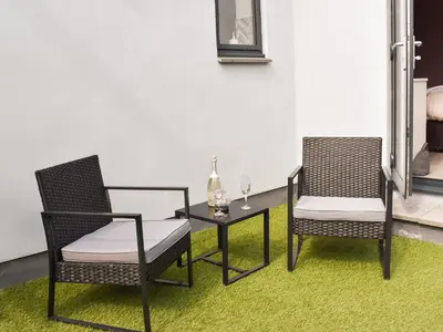 two chairs and a table with a wine glass at Pentarow in Constantine