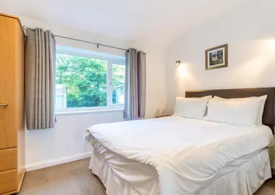 a bedroom with a large bed and a window at Atlantic Reach Holiday Village in Newquay
