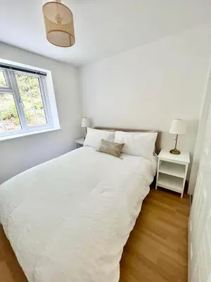 a bedroom with a large white bed with a window at 14 Granite Henge in Looe