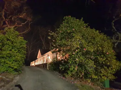 a house on a dirt road at night at Tresillian Lodge Waterfront, Forest, Hot tub,Sauna in Truro