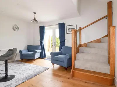 a living room with two chairs and a staircase at Chynoweth House in Newquay