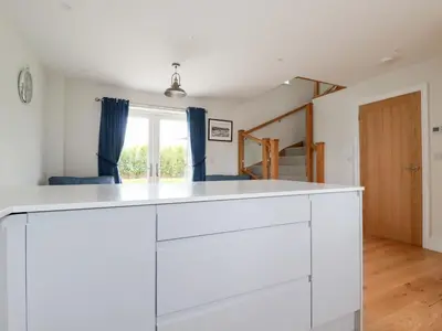 a kitchen with white cabinets and a window at Chynoweth House in Newquay