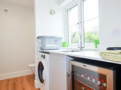 a kitchen with a washing machine and a sink at Chynoweth House in Newquay