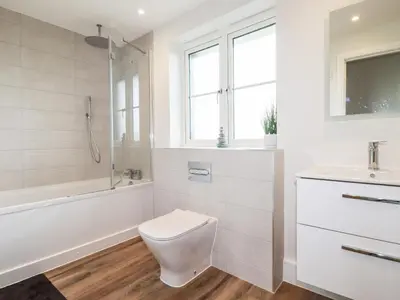 a bathroom with a toilet and a tub and a sink at Chynoweth House in Newquay