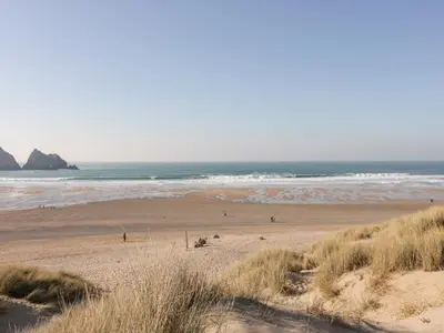 a beach with a group of people in the ocean at Chynoweth House in Newquay
