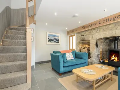 a living room with a blue couch and a fireplace at Stargazy Cottage in Penzance