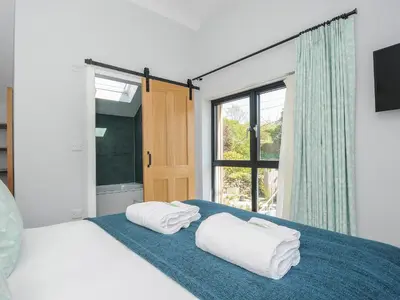 a bedroom with two towels on a bed with a window at Stargazy Cottage in Penzance