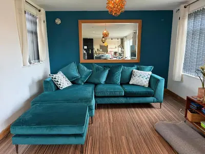 a living room with a blue couch and a mirror at Pasadena in Newquay