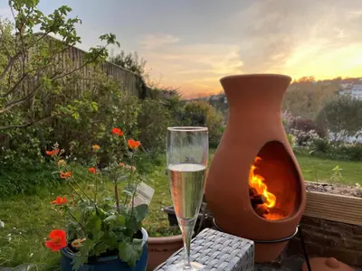 a glass of wine sitting next to a fire pit at Pasadena in Newquay