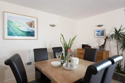 a dining room with a wooden table and chairs at 4 The Vista, Wi-Fi, Pet Friendly in Newquay