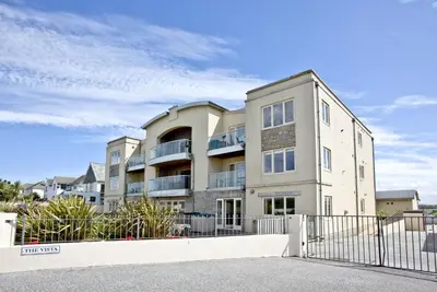 an apartment building with a fence in front of it at 4 The Vista, Wi-Fi, Pet Friendly in Newquay
