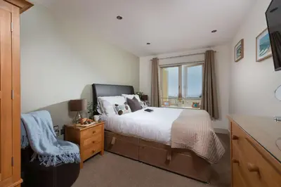 a bedroom with a large bed and a window at 4 The Vista, Wi-Fi, Pet Friendly in Newquay