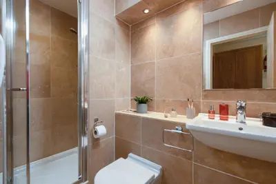 a bathroom with a toilet and a sink and a shower at 4 The Vista, Wi-Fi, Pet Friendly in Newquay