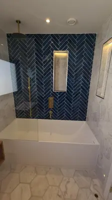 a bathroom with a tub and a blue tiled wall at Luxury home near Fistral Beach in Newquay
