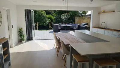 a kitchen and living room with a table and chairs at Luxury home near Fistral Beach in Newquay
