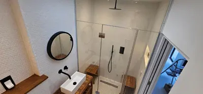 a bathroom with a shower with a sink and a mirror at Luxury home near Fistral Beach in Newquay